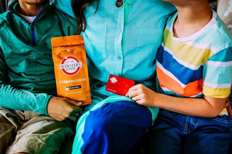 People holding bag of coffee and gift card
